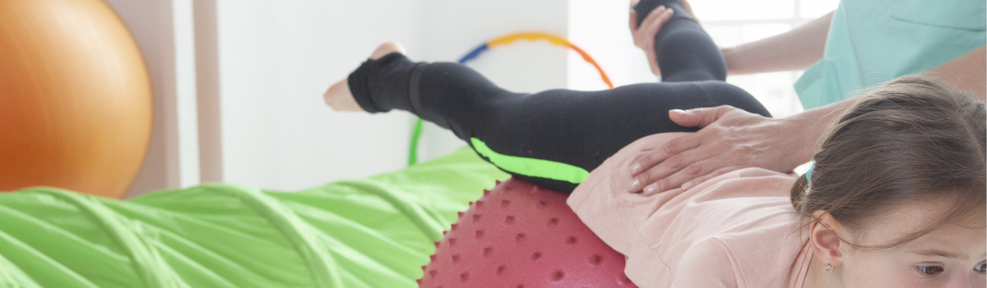 子どもがバランスボールで運動をしている写真